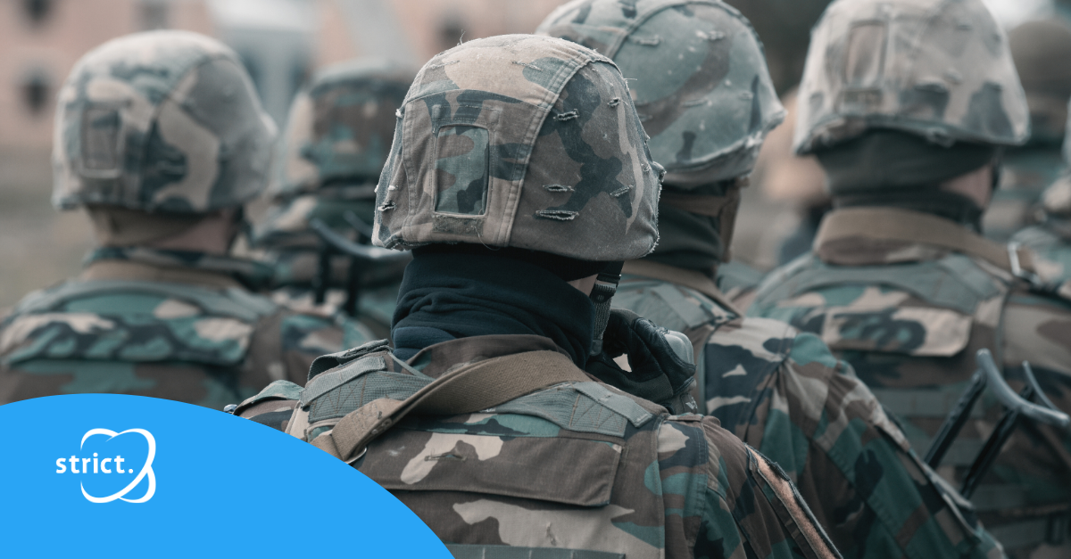 Groep soldaten in camouflage-uniformen, gezien van achteren, tijdens een militaire oefening of operatie.